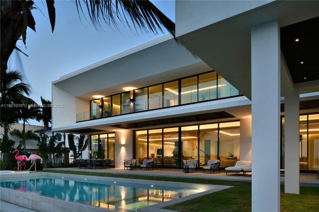 375 N Hibiscus Dr, Miami Beach, FL 33139 - rear view of property featuring outdoor lounge area, a patio, an outdoor pool, and stucco siding