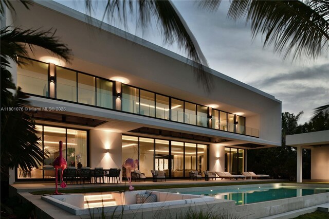 375 N Hibiscus Dr, Miami Beach, FL 33139 - back of property with a balcony, a patio area, an infinity pool, and an outdoor hangout area