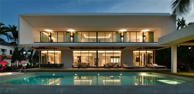 375 N Hibiscus Dr, Miami Beach, FL 33139 - back of house with a balcony, a patio area, an outdoor pool, and stucco siding