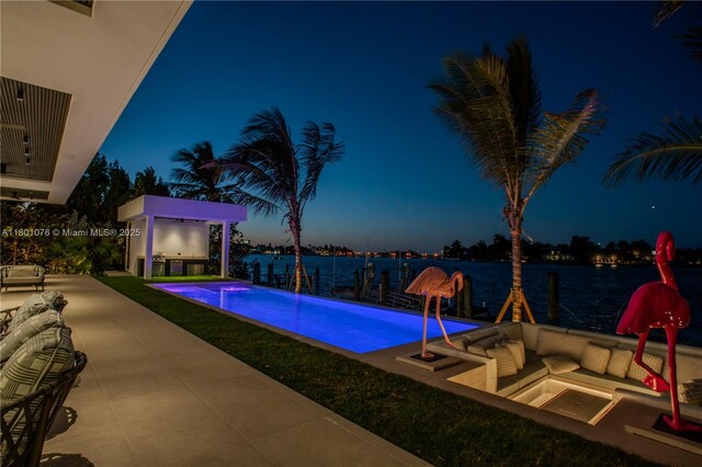 375 N Hibiscus Dr, Miami Beach, FL 33139 - pool at night featuring an outdoor hangout area, a patio area, an outdoor pool, and a water view