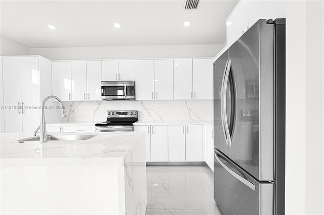 19446 SW 296th St Unit A, Homestead, FL 33030 - kitchen featuring stainless steel appliances, a sink, white cabinets, recessed lighting, and light stone countertops