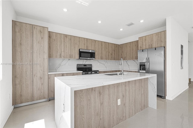 19446 SW 296th St Unit A, Homestead, FL 33030 - kitchen with appliances with stainless steel finishes, a sink, modern cabinets, light stone counters, and a kitchen island with sink