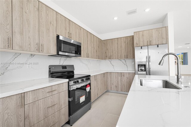 19446 SW 296th St Unit A, Homestead, FL 33030 - kitchen with stainless steel appliances, light brown cabinets, light stone counters, a sink, and recessed lighting