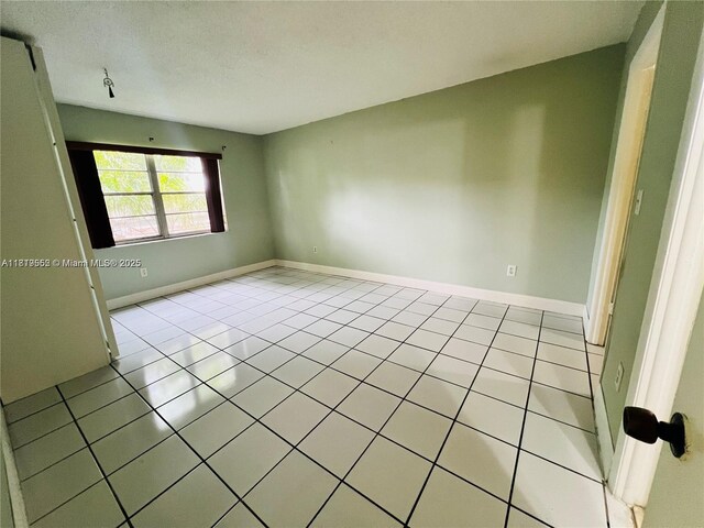 8511 NW 8th St Unit 103, Miami, FL 33126 - spare room featuring light tile patterned floors and baseboards
