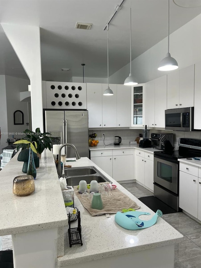 1120 Papaya St, Hollywood, FL 33019 - kitchen with stainless steel appliances, a sink, white cabinetry, hanging light fixtures, and light stone counters