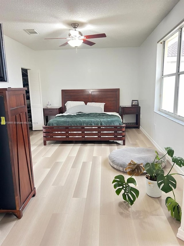 1120 Papaya St, Hollywood, FL 33019 - bedroom with light wood-type flooring, a textured ceiling, and a ceiling fan