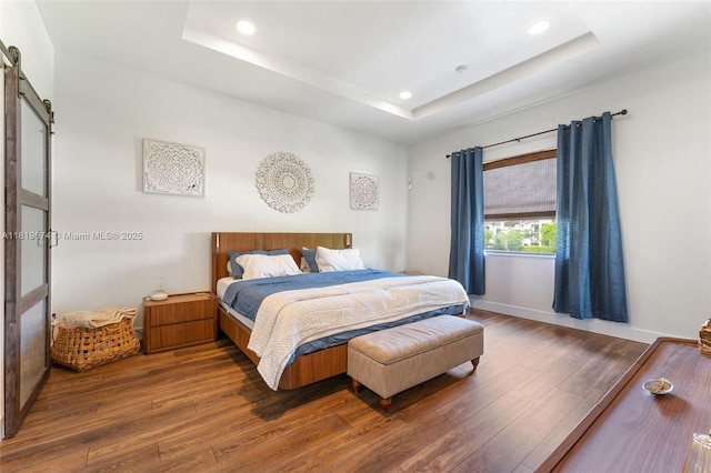27260 SW 136th Path, Homestead, FL 33032 - bedroom with a barn door, a raised ceiling, wood finished floors, and recessed lighting