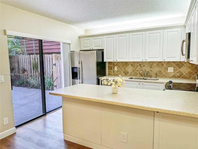 9920 NW 6th Pl Unit 9920, Plantation, FL 33324 - kitchen featuring stainless steel appliances, light countertops, decorative backsplash, wood finished floors, and a peninsula