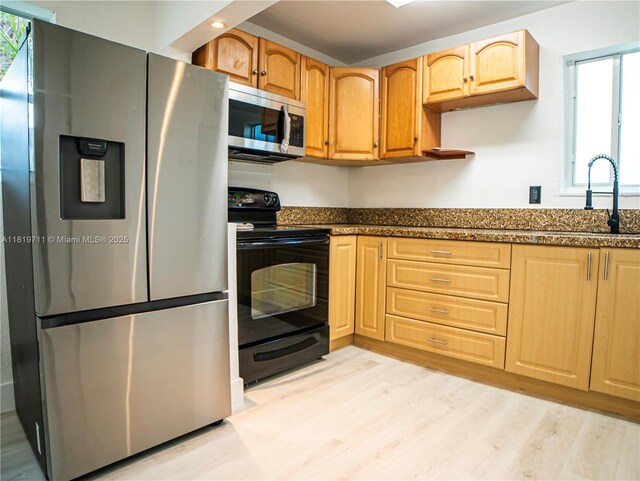 412 Columbus Pkwy, Hollywood, FL 33021 - kitchen featuring appliances with stainless steel finishes, a sink, light wood-style flooring, dark stone countertops, and light brown cabinetry