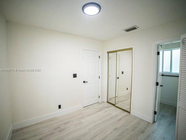 412 Columbus Pkwy, Hollywood, FL 33021 - unfurnished bedroom with light wood-type flooring, baseboards, and a closet