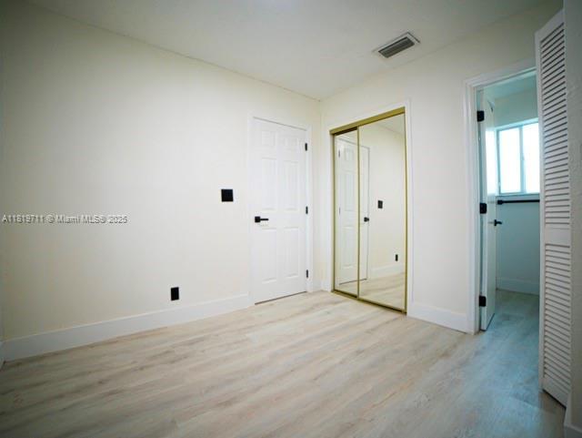412 Columbus Pkwy, Hollywood, FL 33021 - unfurnished bedroom with light wood-style floors, baseboards, and a closet