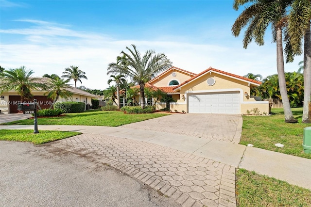 3320 Maple Ln, Davie, FL 33328 - mediterranean / spanish-style home with concrete driveway, a garage, a front yard, stucco siding, and a tiled roof