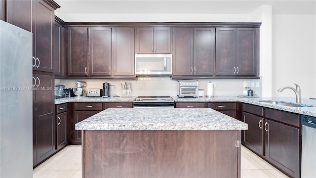 11530 SW 13th Ct, Pembroke Pines, FL 33025 - kitchen featuring stainless steel appliances, a sink, light tile patterned floors, and dark brown cabinets