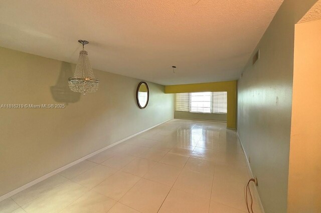 301 Cambridge Rd Unit 302, Hollywood, FL 33024 - hallway featuring a chandelier, a textured ceiling, and light tile patterned floors
