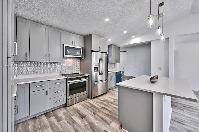 2273 SW Phyllis Ln, Port St Lucie, FL 34953 - kitchen featuring appliances with stainless steel finishes, gray cabinetry, light wood-style floors, decorative backsplash, and recessed lighting