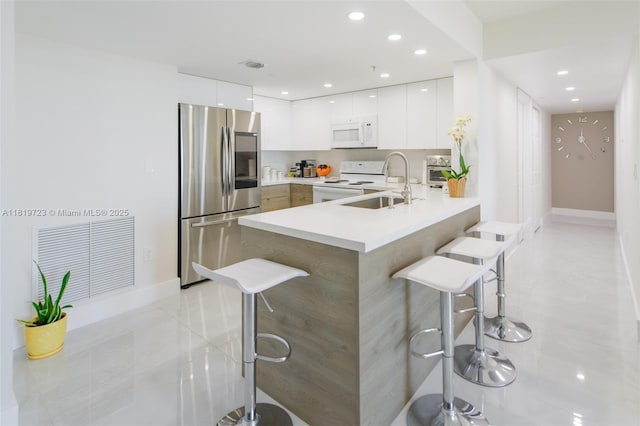 3000 Coral Way Unit 1208, Miami, FL 33145 - kitchen featuring white appliances, modern cabinets, a sink, a kitchen breakfast bar, and recessed lighting