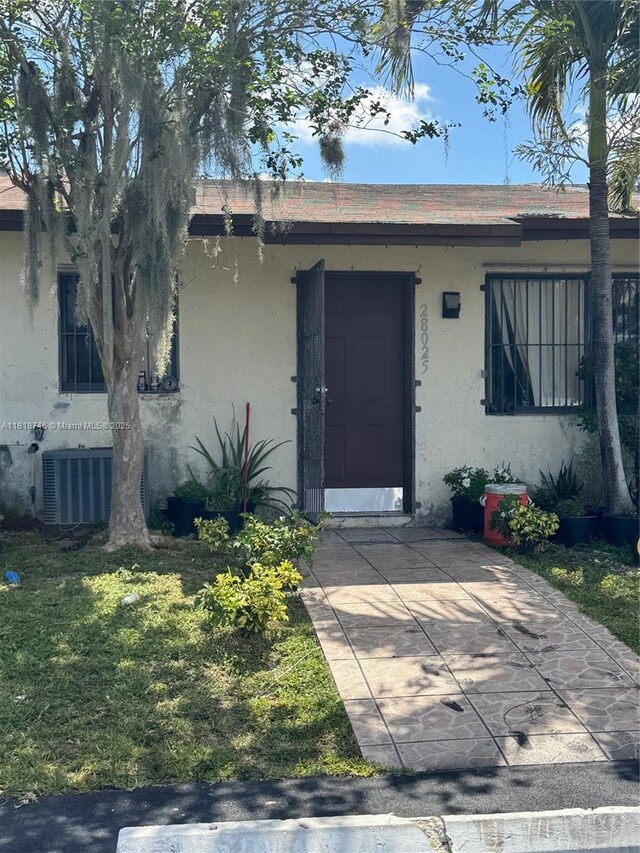 28152 SW 142nd Ct, Homestead, FL 33033 - view of exterior entry featuring stucco siding and central AC