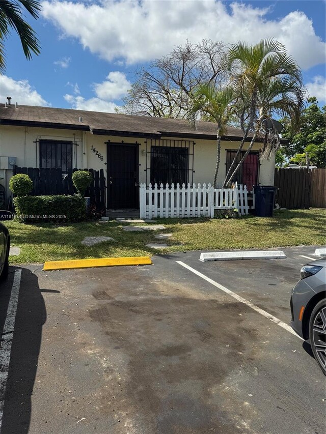 28152 SW 142nd Ct, Homestead, FL 33033 - view of front of house with uncovered parking, a fenced front yard, and stucco siding
