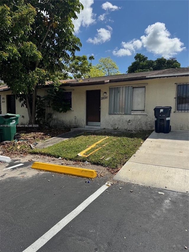 14266 SW 283rd St, Homestead, FL 33033 - view of front of house with stucco siding, a front lawn, and uncovered parking