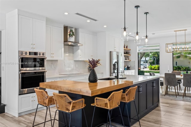 7570 SW 60th St, Miami, FL 33143 - kitchen with wall chimney exhaust hood, stainless steel appliances, a sink, white cabinets, and recessed lighting