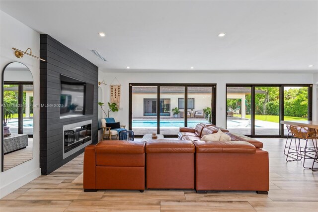 7570 SW 60th St, Miami, FL 33143 - living room featuring a fireplace, recessed lighting, light wood-style flooring, and french doors