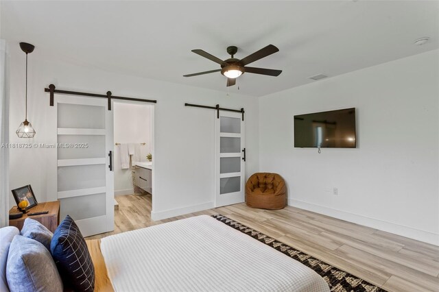 7570 SW 60th St, Miami, FL 33143 - bedroom featuring a barn door, light wood-type flooring, baseboards, and ceiling fan
