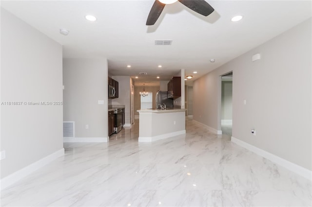 2635 SW Acco Rd, Port St Lucie, FL 34953 - unfurnished living room with a ceiling fan, light marble finish floors, recessed lighting, and a chandelier