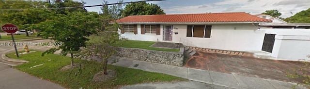 100 NW 23rd Ave, Miami, FL 33125 - view of front of home featuring a tiled roof and stucco siding