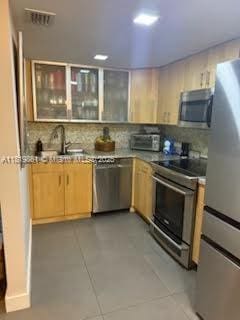 9367 Fontainebleau Blvd Unit G237, Miami, FL 33172 - kitchen with appliances with stainless steel finishes, light brown cabinets, and backsplash
