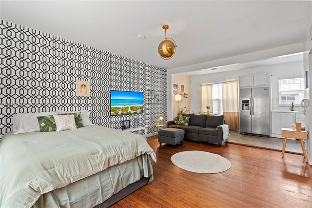 760 Meridian Ave Unit 3, Miami Beach, FL 33139 - bedroom featuring stainless steel fridge with ice dispenser, wood finished floors, a sink, and wallpapered walls