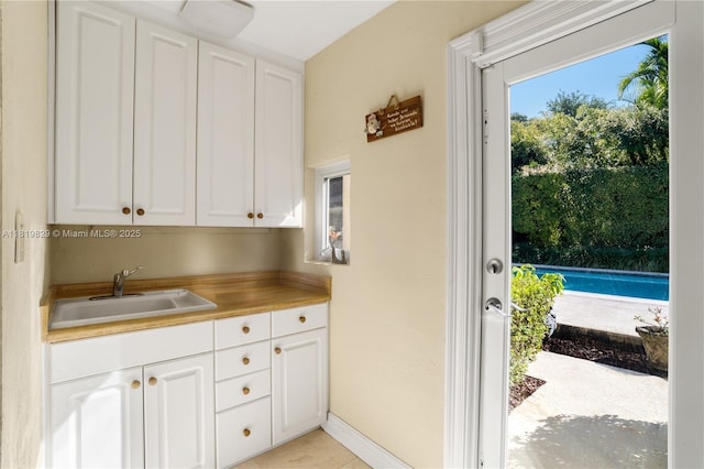 1270 Mariola Ct, Coral Gables, FL 33134 - kitchen featuring a sink, white cabinetry, and light countertops
