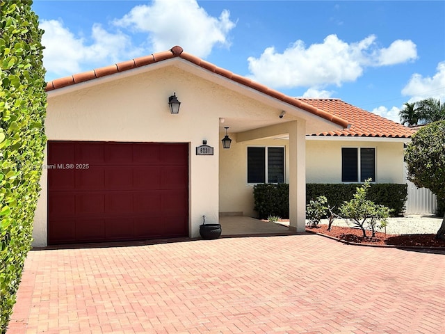 6231 SW 27th St, Miami, FL 33155 - mediterranean / spanish house with an attached garage, stucco siding, a tile roof, and decorative driveway