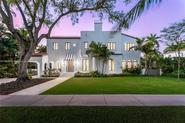 mediterranean / spanish house featuring stucco siding and a chimney