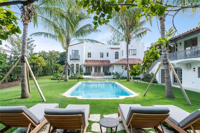 outdoor pool with a yard and a patio