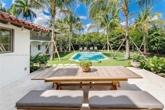 outdoor pool featuring a patio, outdoor dining area, and a yard