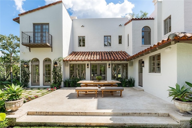 back of property featuring french doors, a patio, and a tiled roof