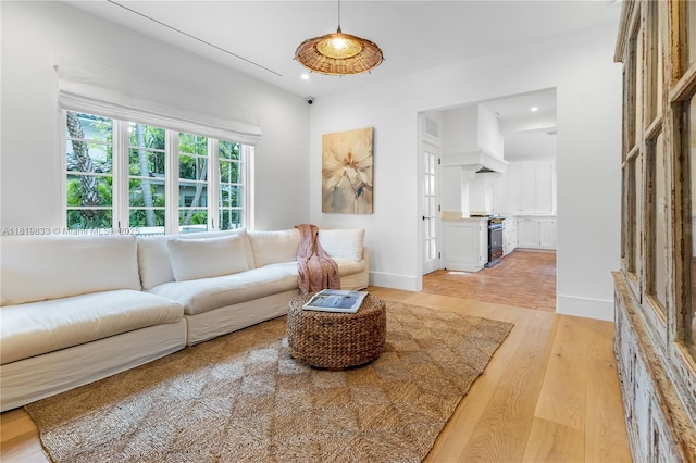 living room with light wood-style flooring, recessed lighting, and baseboards