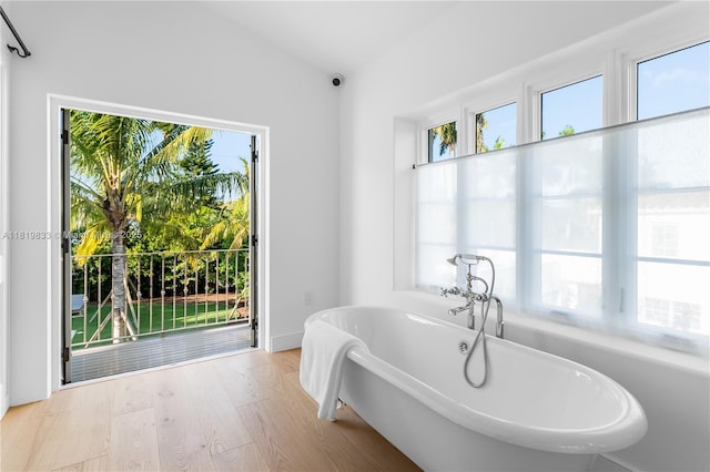 bathroom featuring a freestanding tub and wood finished floors