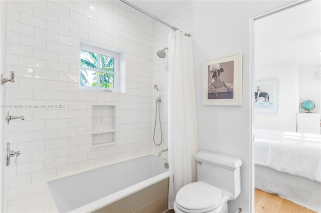 ensuite bathroom featuring shower / bath combination with curtain, toilet, and wood finished floors