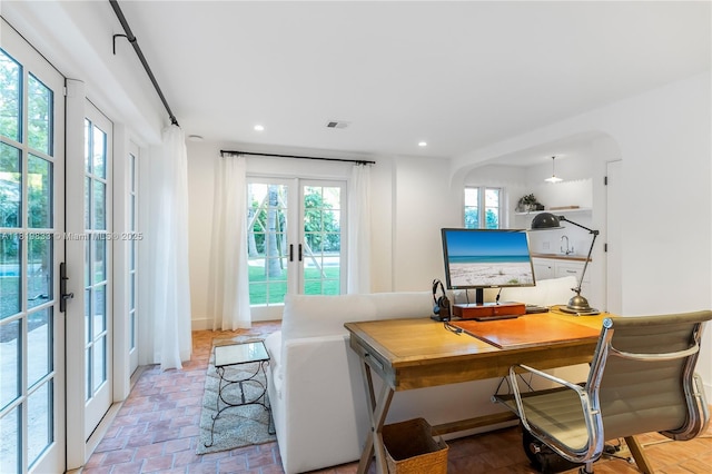 office with french doors, arched walkways, and recessed lighting