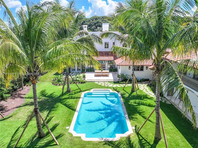 view of pool featuring a patio and a yard