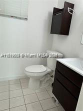 8888 Collins Ave Unit 318, Surfside, FL 33154 - half bath featuring vanity, toilet, tile patterned flooring, and baseboards
