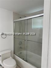 8888 Collins Ave Unit 318, Surfside, FL 33154 - bathroom with shower / bath combination with glass door and toilet