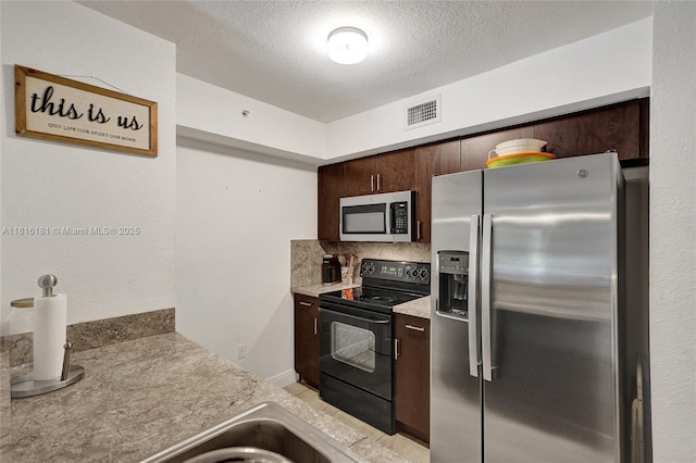 15400 SW 284th St Unit 1204, Homestead, FL 33033 - kitchen featuring stainless steel appliances, dark brown cabinets, backsplash, a textured ceiling, and light countertops
