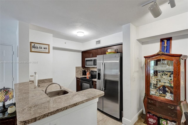 15400 SW 284th St Unit 1204, Homestead, FL 33033 - kitchen featuring stainless steel appliances, a peninsula, backsplash, dark brown cabinets, and light tile patterned floors