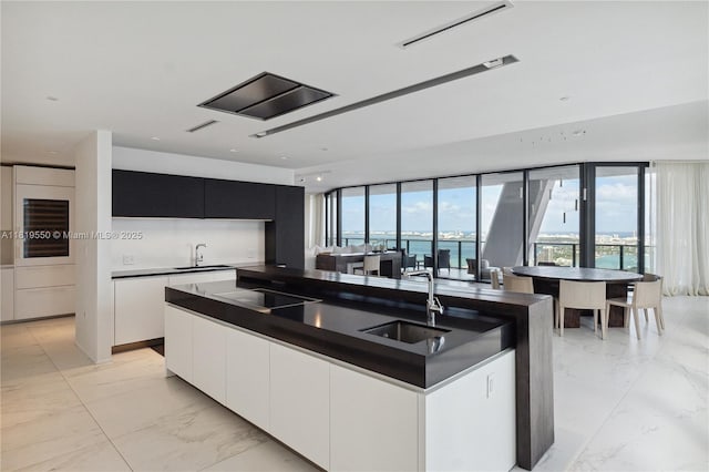 1000 Biscayne Blvd Unit 4401, Miami, FL 33132 - kitchen with a sink, modern cabinets, dark countertops, light marble finish floors, and expansive windows