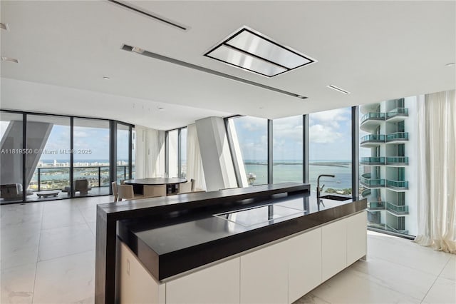 1000 Biscayne Blvd Unit 4401, Miami, FL 33132 - kitchen featuring floor to ceiling windows, white cabinetry, dark countertops, a water view, and a sink