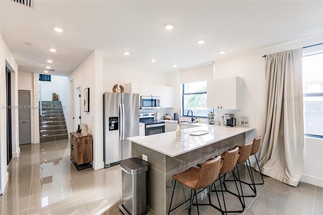3645 SW 3rd St, Miami, FL 33135 - kitchen with stainless steel appliances, a peninsula, healthy amount of natural light, a breakfast bar area, and recessed lighting