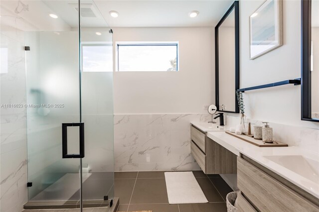 3645 SW 3rd St, Miami, FL 33135 - bathroom with tile walls, double vanity, a shower stall, tile patterned flooring, and a wainscoted wall
