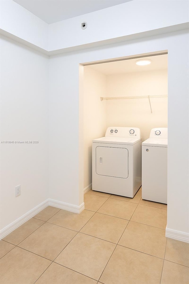 4242 NW 2nd St Unit 807, Miami, FL 33126 - laundry area featuring separate washer and dryer, light tile patterned floors, and baseboards